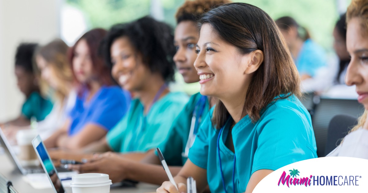 Several students in scrubs happily attend a class, representing caregiver training.