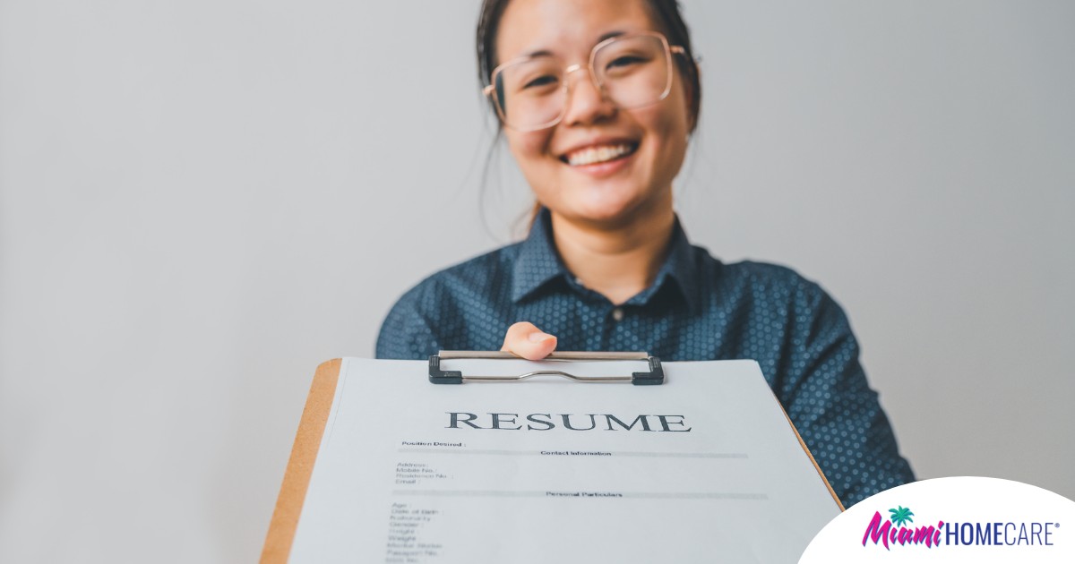 A woman happily hands in a resume, representing a successfully written caregiver resume.