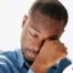 A man tiredly rubs his eyes, representing the exhaustion that can come with family caregiving.